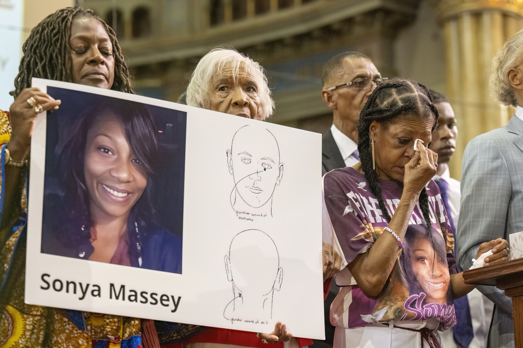 FILE - Donna Massey, center right, wipes tears from her face as she listens to Rev. Al Sharpton, right, speak during a press conference Tuesday, July 30, 2024, in Chicago, over the shooting death of her daughter Sonya, who was allegedly killed by Illinois sheriff's deputy Sean Grayson. (Tyler Pasciak LaRiviere/Chicago Sun-Times via AP)