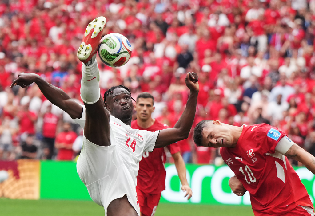 Canada's Promise David (24) takes a shot on goal as Switzerland's Granit Xhaka (10) defends during the World Cup Group B soccer match between Switzerland and Canada in Vancouver, British Columbia, Wednesday, June 24, 2026. (Darryl Dyck/The Canadian Press via AP)