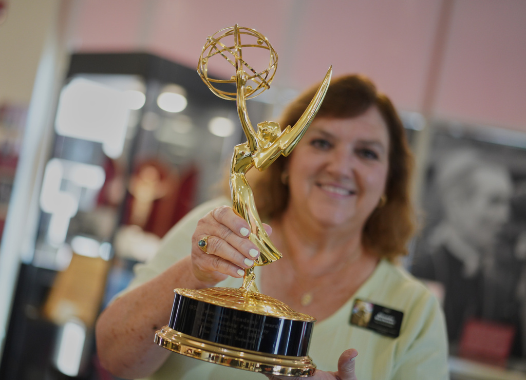 The Archbishop Fulton Sheen Museum tour coordinator, Rhonda Bachman, holds an Emmy award won by the late Archbishop Fulton Sheen, in Peoria, Ill., on July 15, 2026. (AP Photo/Jessie Wardarski)
