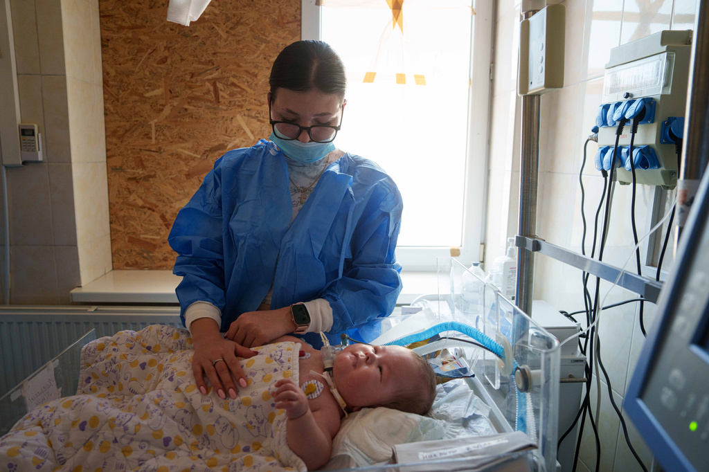 Dasha Kosmin touches her son Mark at the ICU department of the children's regional hospital in Zaporizhzhia, Ukraine, Thursday, May 7, 2026. (AP Photo/Evgeniy Maloletka)