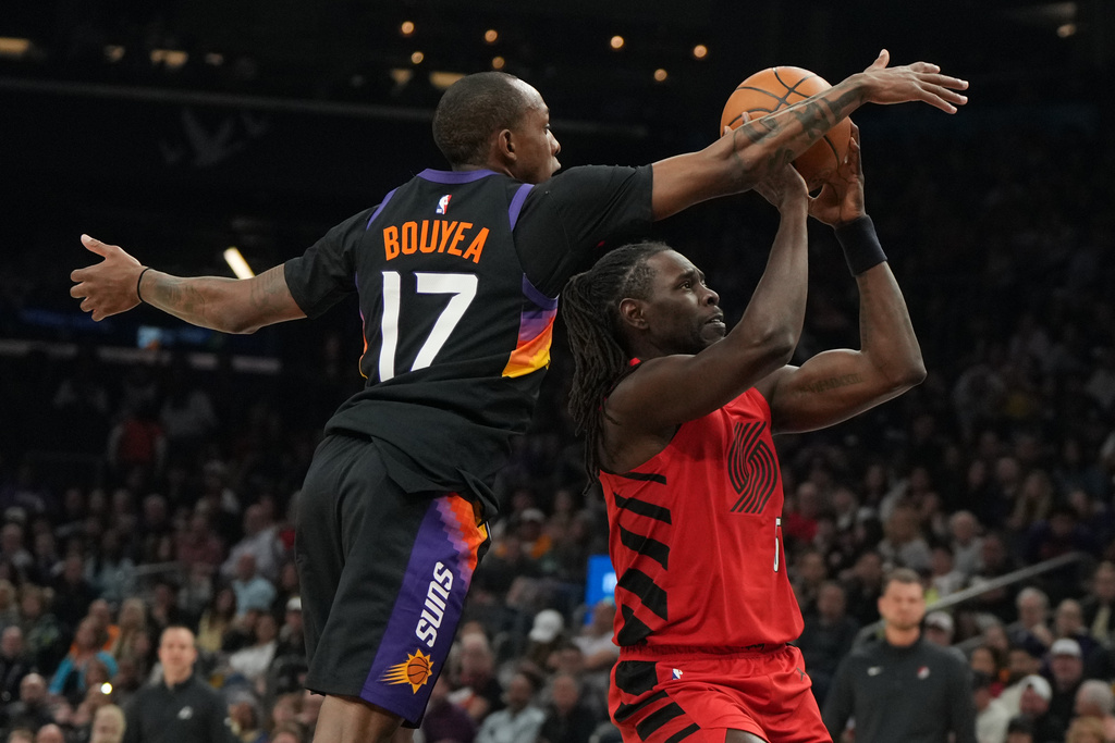 Phoenix Suns guard Jamaree Bouyea (17) pressures Portland Trail Blazers guard Jrue Holiday, right, during the first half of an NBA basketball game, Sunday, Feb. 22, 2026, in Phoenix. (AP Photo/Rick Scuteri)