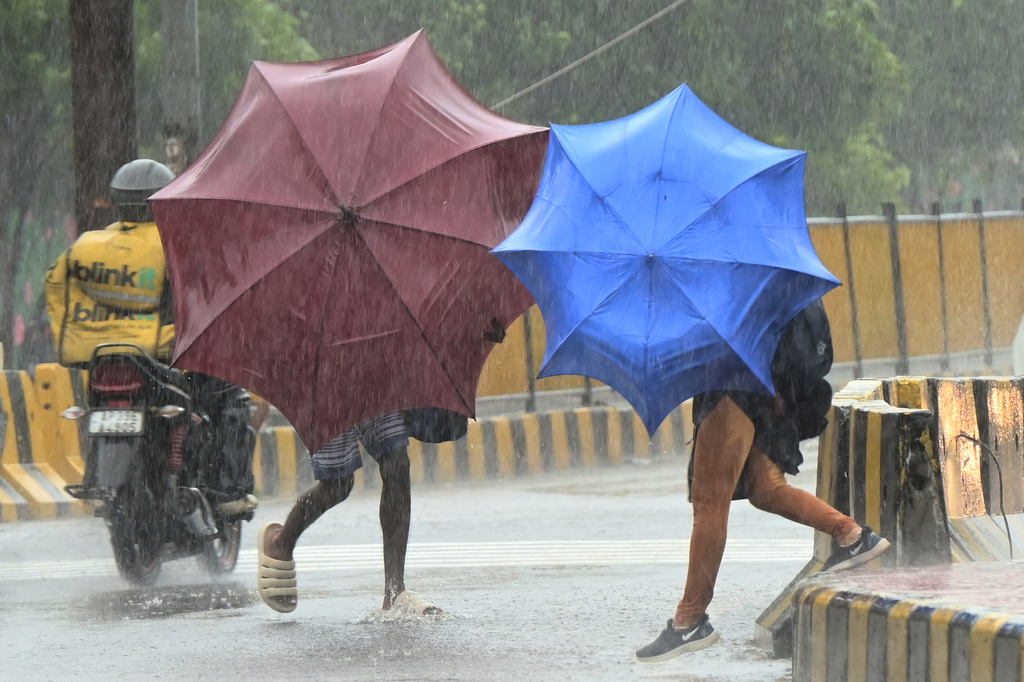 People use umbrellas to shield themselves from strong winds as Cyclone Arnab approaches the Andhra Pradesh coast, in Visakhapatnam, India, Tuesday, Oct. 27, 2026. (AP Photo)