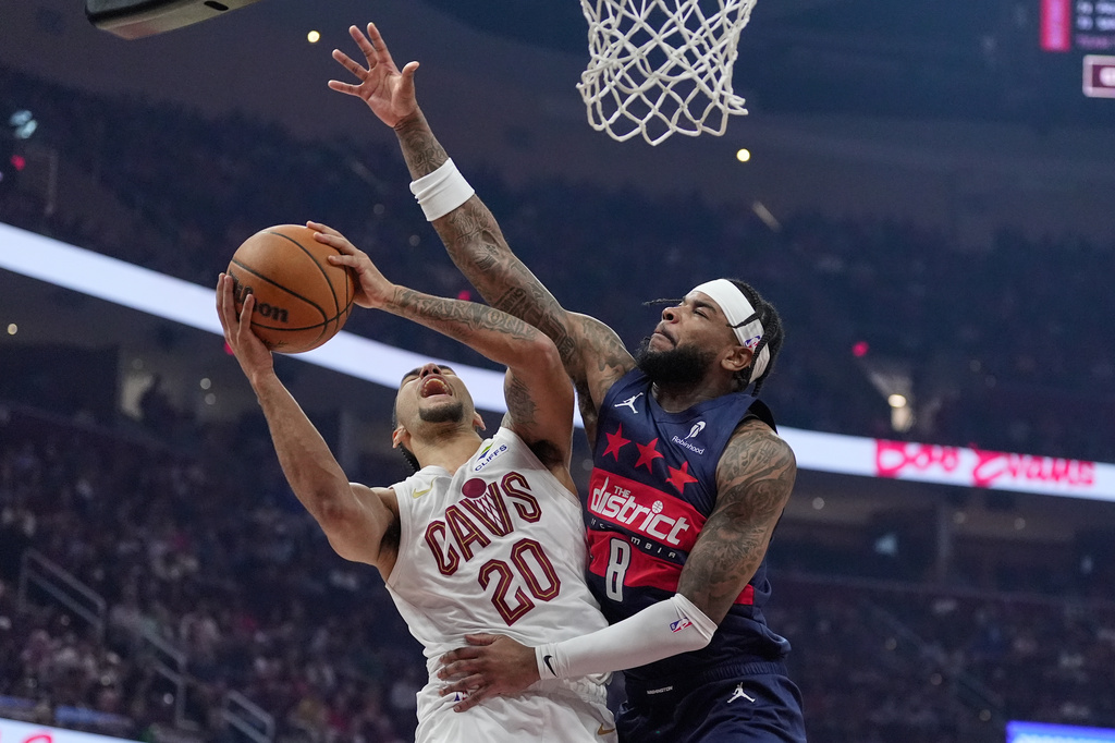 Cleveland Cavaliers guard Jaylon Tyson (20) shoots as Washington Wizards guard Jaden Hardy (8) defends in the first half of an NBA basketball game in Cleveland, Sunday, April 12, 2026. (AP Photo/Sue Ogrocki)
