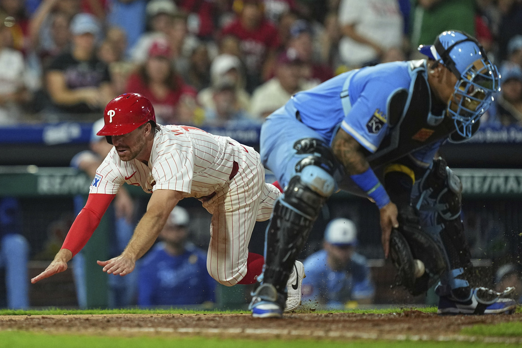 Philadelphia Phillies' Donovan Walton, left, scores past Kansas City Royals catcher Salvador Perez off of a RBI single by Kyle Schwarber during the sixth inning of a baseball game, Saturday, Sept. 13, 2025, in Philadelphia. (AP Photo/Matt Rourke)