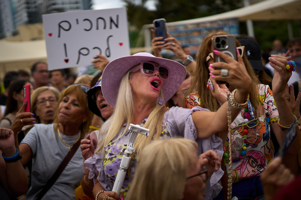 People react as they celebrate following the announcement that Israel and Hamas have agreed to the first phase of a peace plan to pause the fighting, at a plaza known as hostages square in Tel Aviv, Israel, Thursday, Oct. 9, 2025. (AP Photo/Emilio Morenatti)