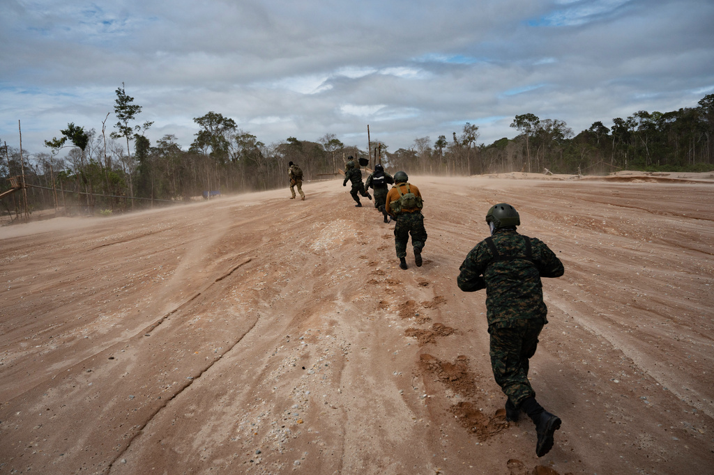 Peruvian Navy soldiers run as they get off a helicopter during an operation to combat illegal mining in the Tambopata National Reserve in Puerto Maldonado, Peru, Tuesday, Aug. 11, 2026. (AP Photo/Guadalupe Pardo)