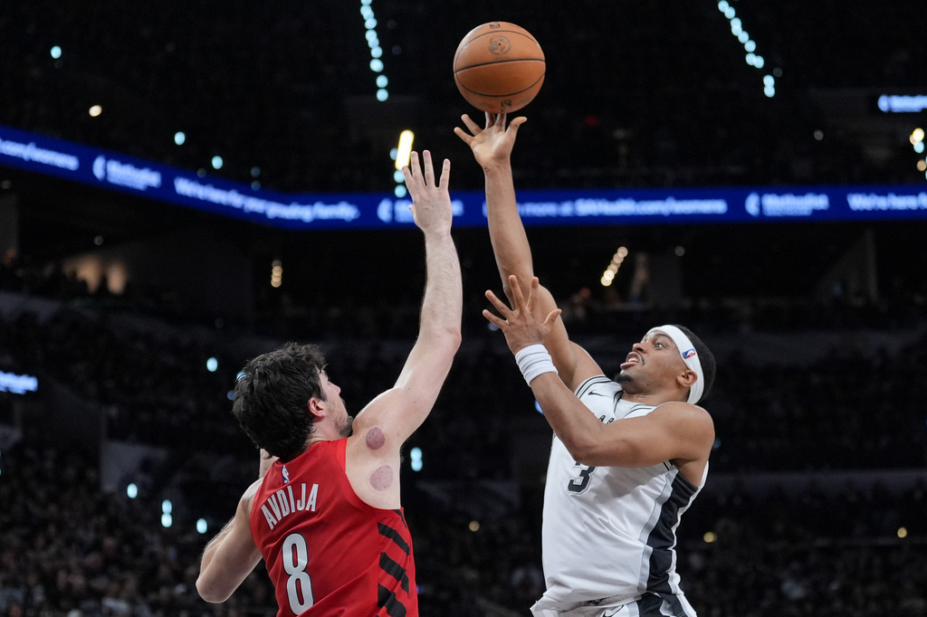 San Antonio Spurs forward/guard Keldon Johnson (3) goes to the basket as Portland Trail Blazers forward Deni Avdija (8) defends during the second half in Game 5 of a first-round NBA playoffs basketball series in San Antonio, Tuesday, April 28, 2026. (AP Photo/Eric Gay)