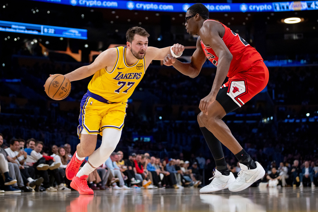 Los Angeles Lakers guard Luka Doncic (77) is defended by Chicago Bulls forward Jalen Smith, right, during the first half of an NBA basketball game against the Chicago Bulls, Thursday, March 12, 2026, in Los Angeles. (AP Photo/Ethan Swope)