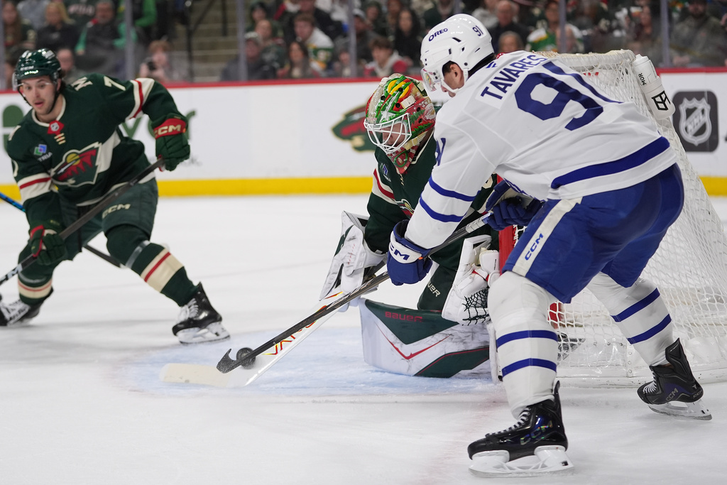 Minnesota Wild goaltender Jesper Wallstedt blocks a shot by Toronto Maple Leafs center John Tavares, right, during the second period of an NHL hockey game, Sunday, March 15, 2026, in St. Paul, Minn. (AP Photo/Abbie Parr)