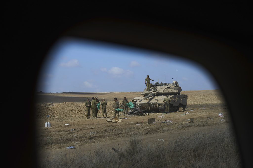 Israeli soldiers work on their tank at a staging area on the border with Gaza Strip, in southern Israel, Tuesday, Sep.9 2025. (AP Photo/Ariel Schalit)