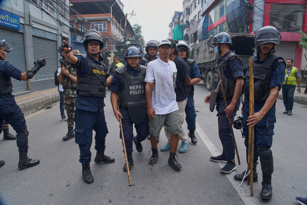 Policemen arrest a prisoner who escaped from Dilli Bazaar jail in Kathmandu, Nepal, Wednesday, Sept. 10, 2025. (AP Photo/Niranjan Shrestha)