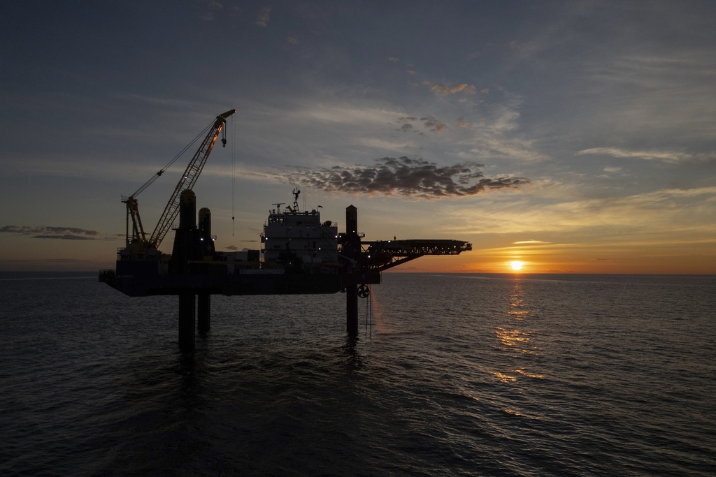 The sun sets behind the Liftboat Robert platform, home of Expedition 501, in the North Atlantic, Saturday, July 19, 2025. (AP Photo/Carolyn Kaster)