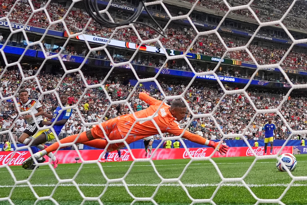 Curaçao goalkeeper Eloy Room (1) is beaten by a shot from Germany's Jamal Musiala (10), left, to score their fourth goal during the World Cup Group E soccer match between Germany and Curacao in Houston, Sunday, June 14, 2026. (AP Photo/Eric Gay)
