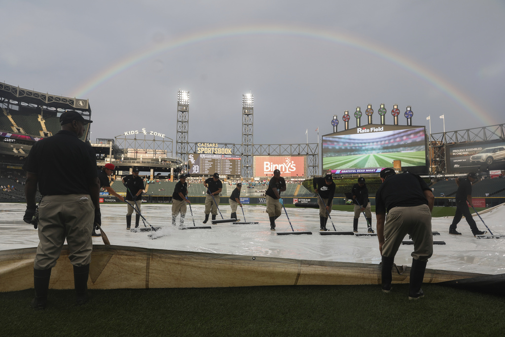 A rainbow is seen as grounds crew members clear water off a tarp prior to a baseball game between the Chicago White Sox and the Detroit Tigers, Tuesday, Aug. 12, 2025 in Chicago. (AP Photo/Talia Sprague)