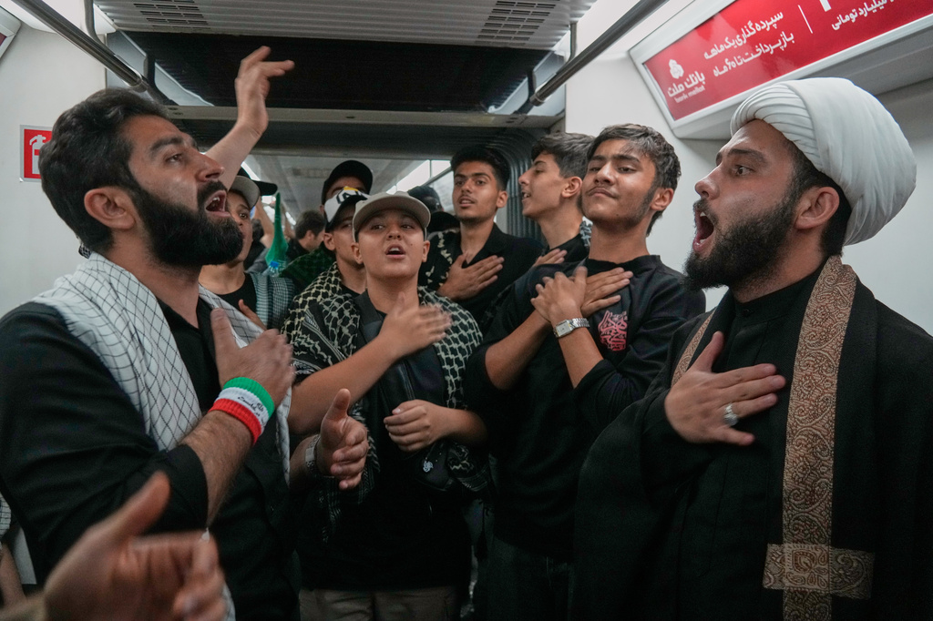 Men beat their chests aboard a subway train as they travel to attend the funeral procession of the slain Iranian Supreme Leader Ayatollah Ali Khamenei in Tehran, Iran, Monday, July 6, 2026. (AP Photo/Vahid Salemi)
