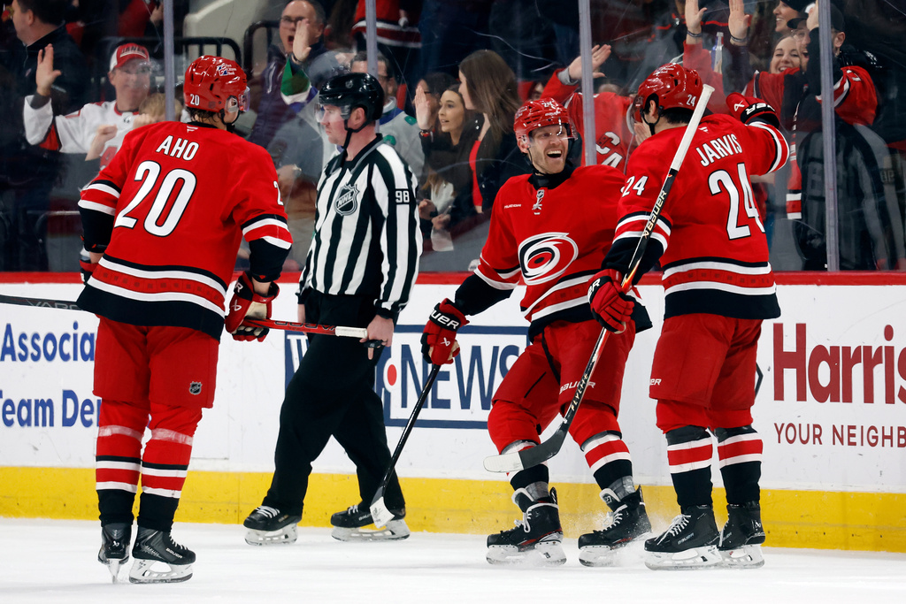 Carolina Hurricanes' Nikolaj Ehlers celebrates his hat trick goal against the Florida Panthers with teammates Seth Jarvis (24) and Sebastian Aho during the third period of an NHL hockey game in Raleigh, N.C., Friday, Jan. 16, 2026. (AP Photo/Karl DeBlaker)