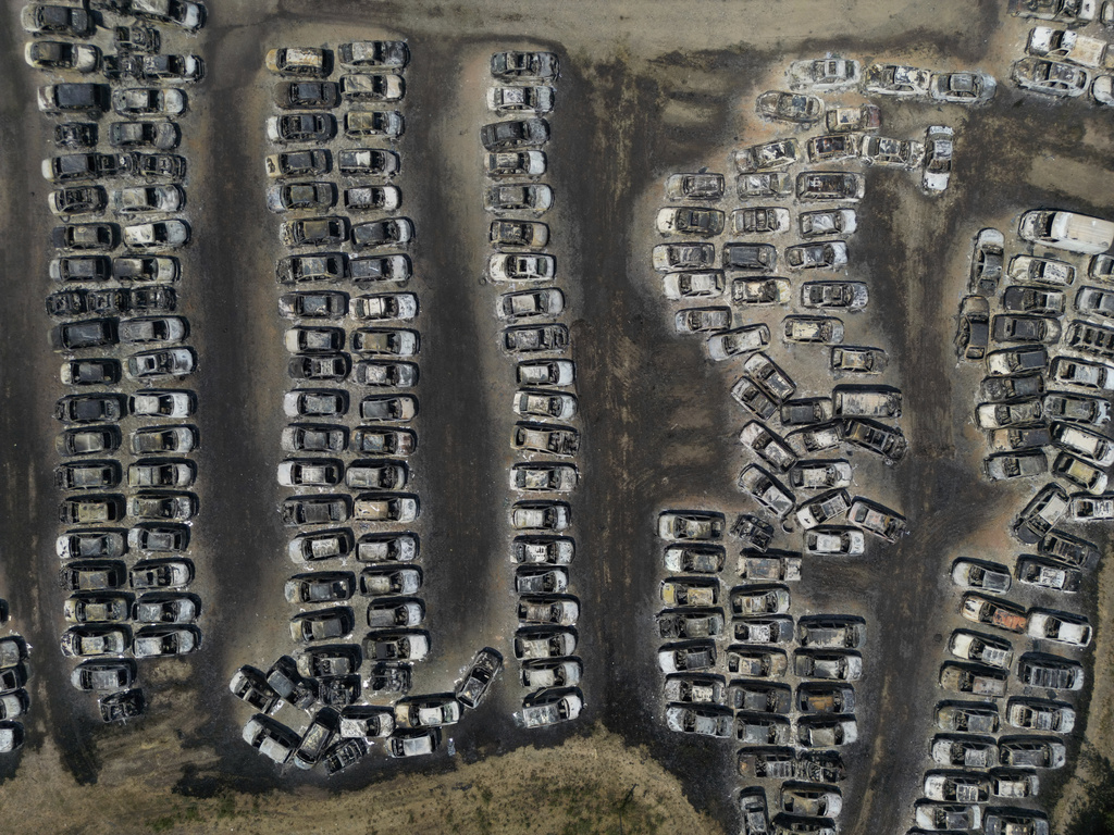 Burned cars are seen at an impound lot in Kato Achaia, during a wildfire near Patras city, western Greece, Wednesday, Aug. 13, 2025. (AP Photo/Thanassis Stavrakis)