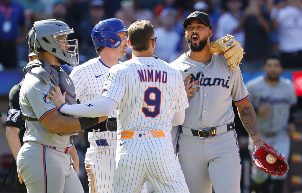 New York Mets' Brandon Nimmo (9) talks to Miami Marlins pitcher Sandy Alcantara after hitting Mets' Mark Vientos during the seventh inning of a baseball game, Sunday, Aug. 31, 2025, in New York. (AP Photo/Noah K. Murray)