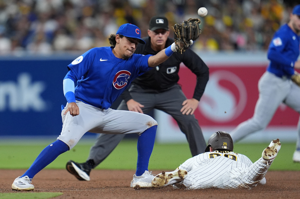 San Diego Padres' Bryce Johnson, below, safely steals second base as Chicago Cubs second baseman Nicky Lopez misses the catch during the fifth inning of a baseball game Tuesday, April 28, 2026, in San Diego. (AP Photo/Gregory Bull)