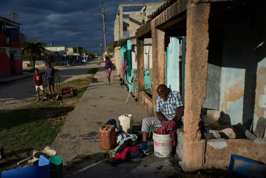 Former baseball player Juan Alberto Varona washes clothes in the street during a scheduled power outage in Santa Cruz del Norte, Cuba, late afternoon Tuesday, Feb. 3, 2026. (AP Photo/Ramon Espinosa)