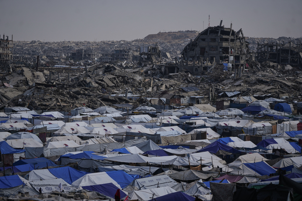 Tents sheltering displaced Palestinians stand amid the destruction left by the Israeli air and ground offensive in Gaza City Friday, Dec. 5, 2025. (AP Photo/Abdel Kareem Hana)