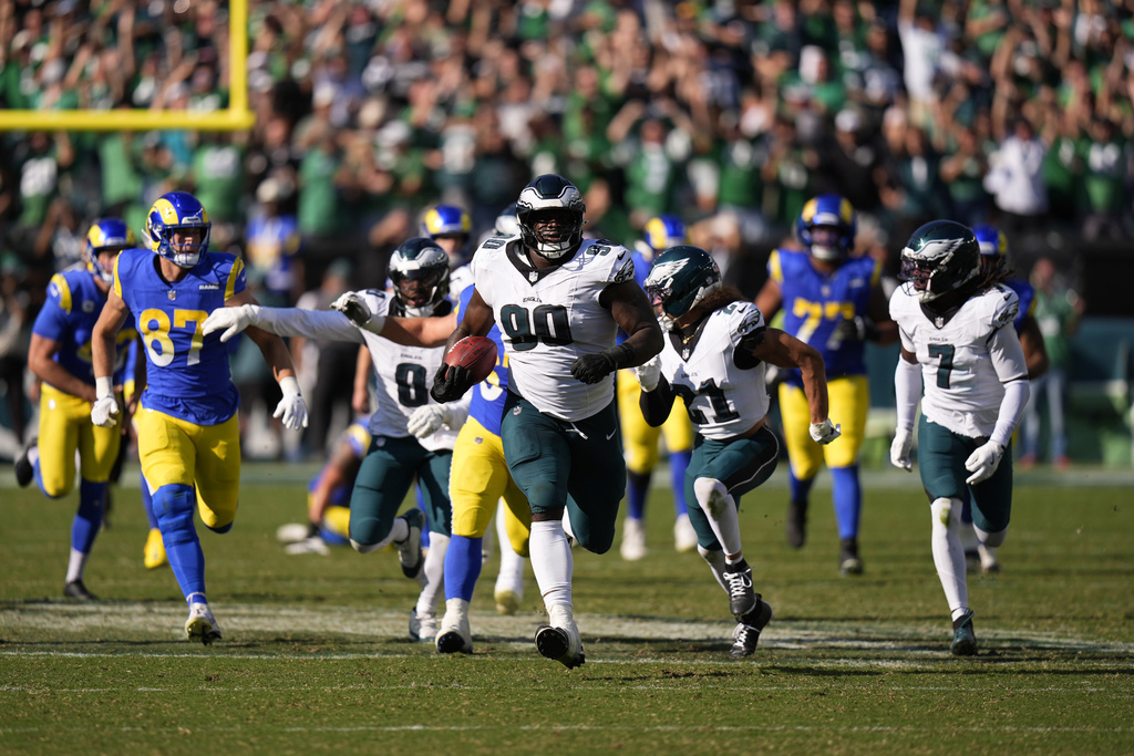 Philadelphia Eagles defensive tackle Jordan Davis (90) runs the ball back for a touchdown after blocking a field goal attempt as time expires during the second half of an NFL football game against the Los Angeles Rams Sunday, Sept. 21, 2025, in Philadelphia. (AP Photo/Chris Szagola)