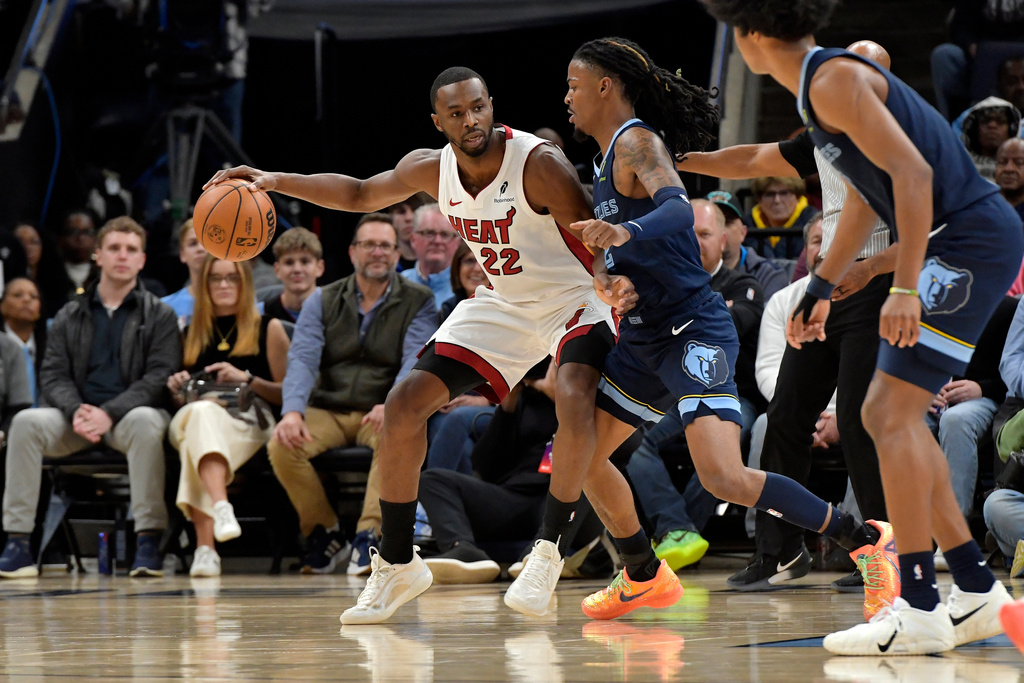 Miami Heat forward Andrew Wiggins (22) handles the ball against Memphis Grizzlies guard Ja Morant in the first half of an NBA basketball game Friday, Oct. 24, 2025, in Memphis, Tenn. (AP Photo/Brandon Dill)
