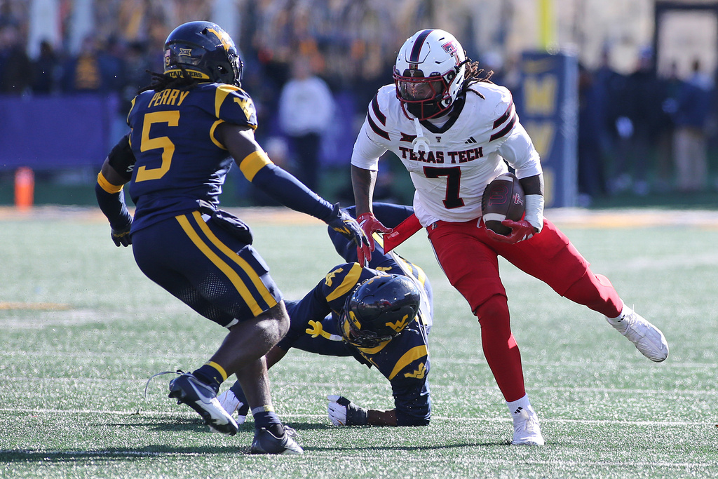Texas Tech tight end Terrance Carter Jr. (7) is defended by West Virginia safety Fred Perry (5)during the first half of an NCAA college football game Saturday, Nov. 29, 2025, in Morgantown, W.Va. (AP Photo/Kathleen Batten)