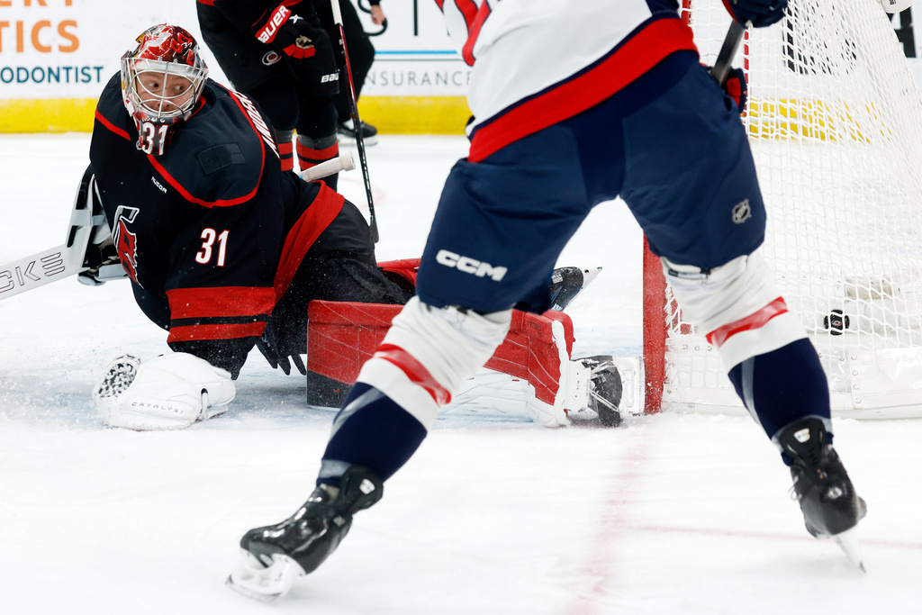 Washington Capitals' Brandon Duhaime stuffs the puck past Carolina Hurricanes goaltender Frederik Andersen (31) for a goal during the first period of an NHL hockey game in Raleigh, N.C., Tuesday, Nov. 11, 2025. (AP Photo/Karl DeBlaker)