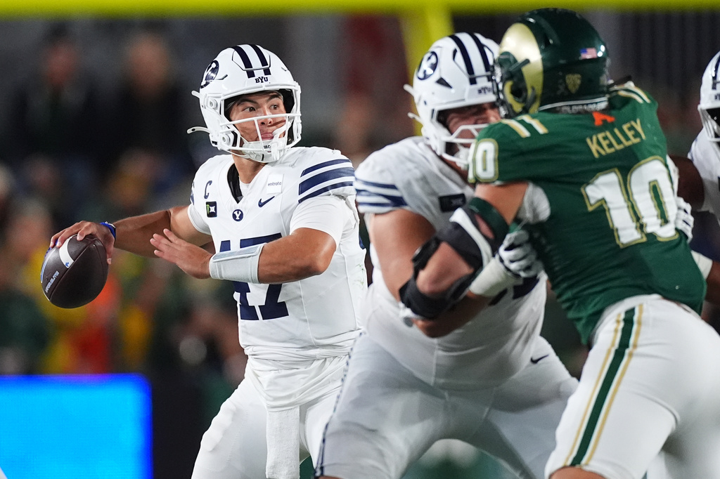 BYU quarterback Bear Bachmeier, left, looks to pass the ball as Colorado State defensive lineman Brandon Kelley (10) pursues in the second half of an NCAA college football game Saturday, Sept. 19, 2026, in Fort Collins, Colo. (AP Photo/David Zalubowski)