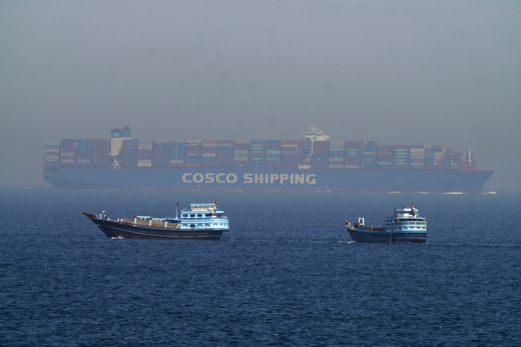 FILE - Two traditional dhows sail by a large container ship in the Strait of Hormuz, May 19, 2023. (AP Photo/Jon Gambrell, File)