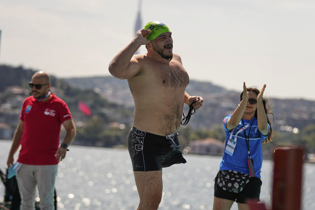Ukrainian war veteran Oleksandr Dashko crosses the finish line during a 6.5km swimming race across the Bosporus Strait, from the Asian side to the European side, in Istanbul, Turkey, Sunday, Aug. 24, 2025. (AP Photo/Khalil Hamra)