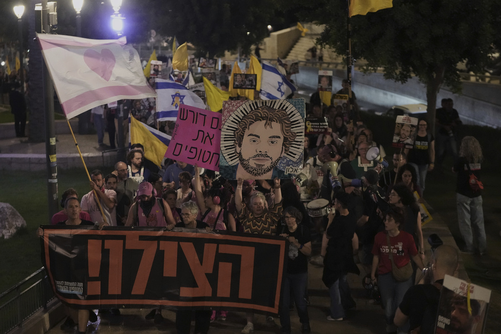 Holding a banner with a message in Hebrew asking for help, relatives and supporters of Israeli hostages held in the Gaza Strip take part in protest demanding their release from Hamas captivity and calling for an end to the war, outside the Old City of Jerusalem, Saturday, Sept. 20, 2025. (AP Photo/Mahmoud Illean)