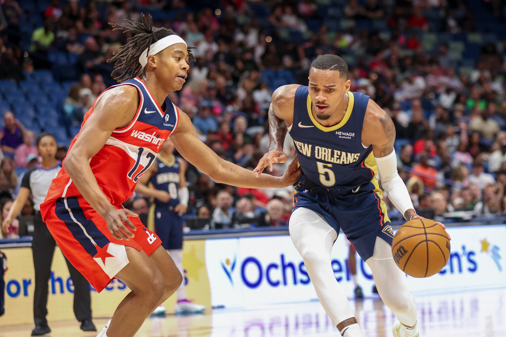 New Orleans Pelicans guard Dejounte Murray (5) tries to drive past Washington Wizards guard Tre Johnson (12) in the first half of an NBA basketball game in New Orleans, Sunday, March 8, 2026. (AP Photo/Peter Forest)