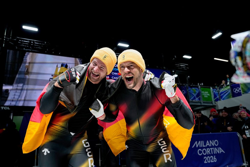 Germany's gold medalists Johannes Lochner, left, and Georg Fleischhauer celebrate at the finish after the two man bobsled competition at the 2026 Winter Olympics, in Cortina d'Ampezzo, Italy, Tuesday, Feb. 17, 2026. (AP Photo/Alessandra Tarantino)
