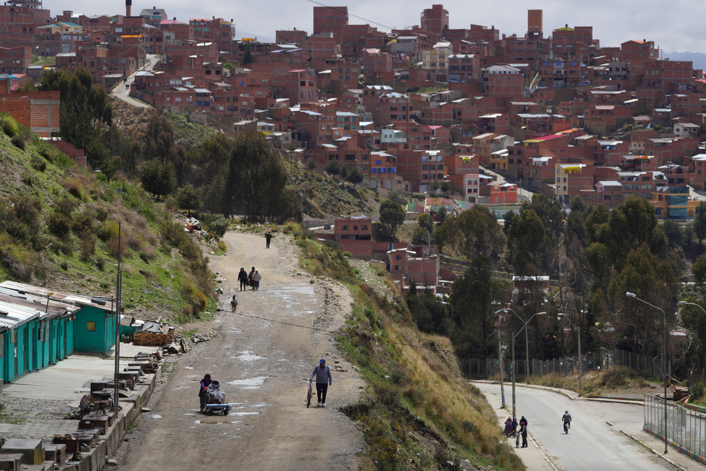 Pedestrians walk during a presidential runoff election in La Paz, Bolivia, Sunday, Oct. 19, 2025. (AP Photo/Ivan Valencia)