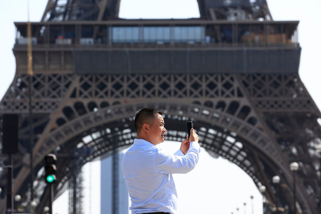 FILE - A person uses his phone near the Eiffel Tower in Paris, Wednesday, Aug. 31, 2022. (AP Photo/Aurelien Morissard, File)