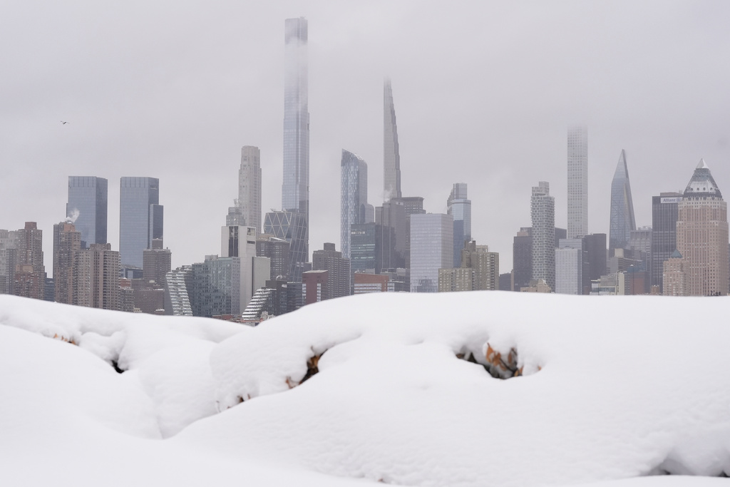 A piece of the New York skyline rises above a pile of snow on the Weekhawken, N.J. waterfront, Monday, Feb. 23, 2026. (AP Photo/Seth Wenig)
