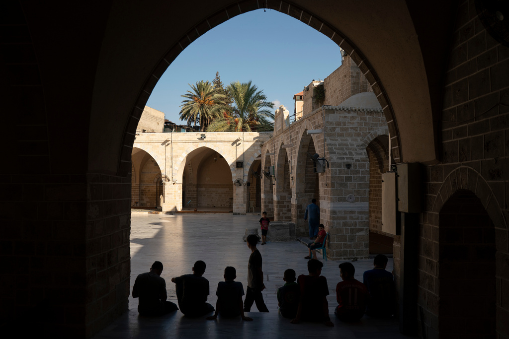 FILE - Palestinians gather outside the Great Omari Mosque after the afternoon prayer in Gaza City. Friday, Sept. 14, 2018. (AP Photo/Felipe Dana, File)