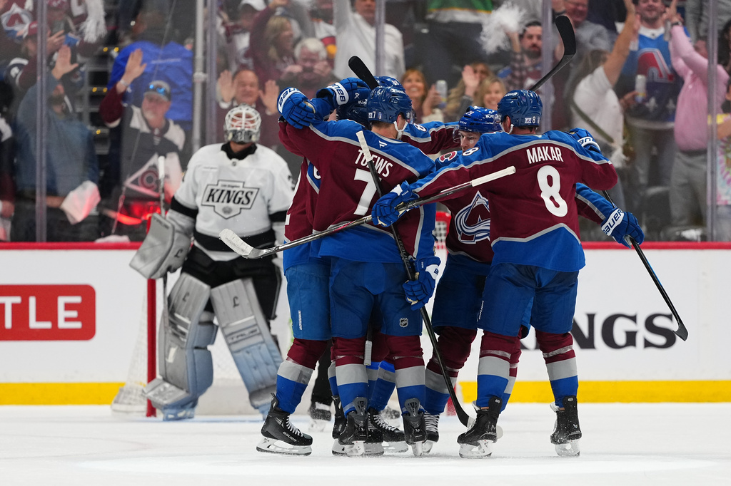 Colorado Avalanche left wing Artturi Lehkonen (partially obscured) celebrates after a goal against Los Angeles Kings goaltender Anton Forsberg, left, with teammates, including Devon Toews (7) and Cale Makar (8), during the second period of Game 1 in the first round of the NHL hockey Stanley Cup playoffs, Sunday, April 19, 2026, in Denver. (AP Photo Jack Dempsey)
