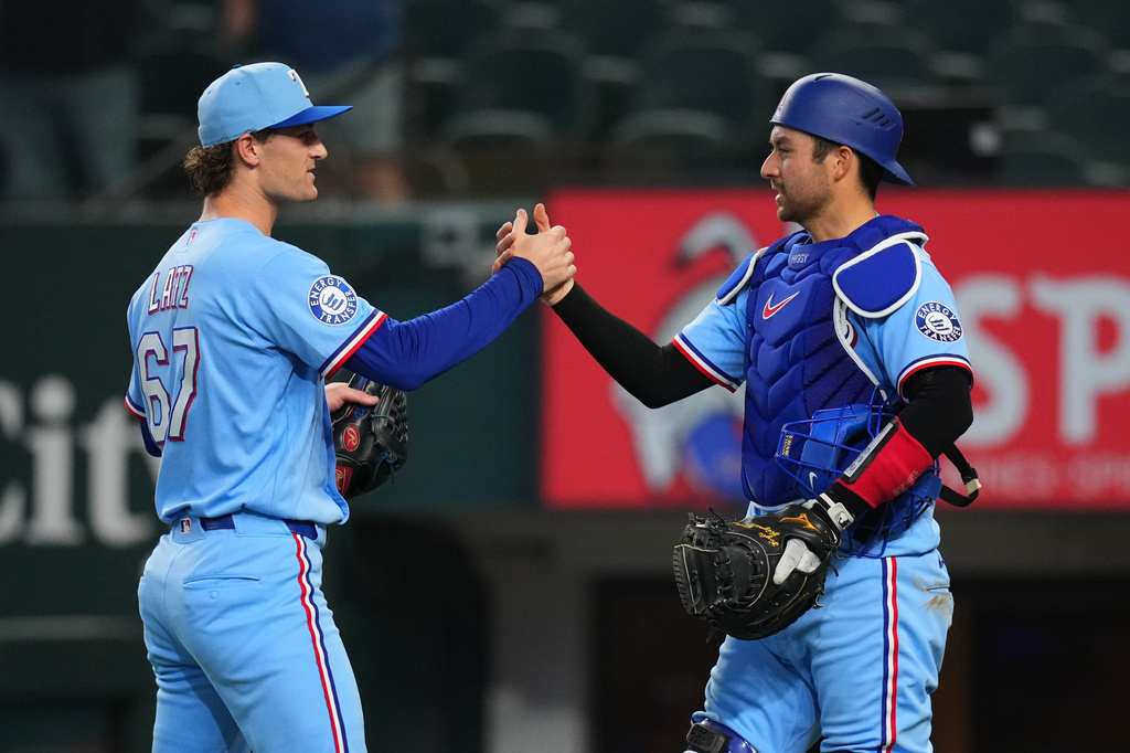Texas Rangers pitcher Jacob Latz, left, and catcher Kyle Higashioka (11) react after their team defeated the Kansas City Royals during a baseball game Sunday, May 31, 2026, in Arlington. (AP Photo/Julio Cortez)