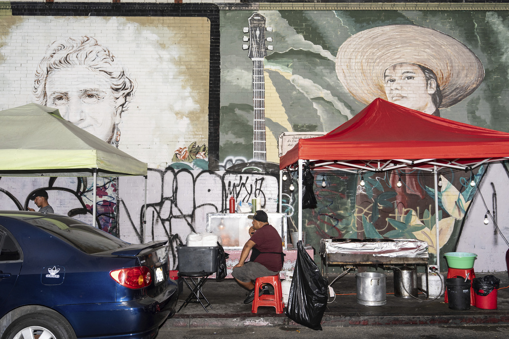 Street vendor Hector, an immigrant from Guatemala, waits for customers at his food cart in Los Angeles, Tuesday, Aug. 5, 2025. (AP Photo/Jae C. Hong)