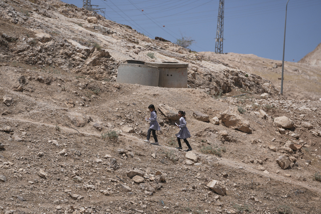 Palestinian students walk on their way home after receiving their year end reports from school, in the West Bank Bedouin hamlets of Khan al-Ahmar, Wednesday, June 10, 2026. (AP Photo/Mahmoud Illean)