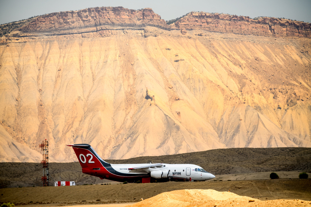 A firefighting aircraft rests on the tarmac at Grand Junction Regional Airport in Grand Junction, Colo., as the Snyder Fire burns nearby on Sunday, June 28, 2026. (AP Photo/Noah Berger)
