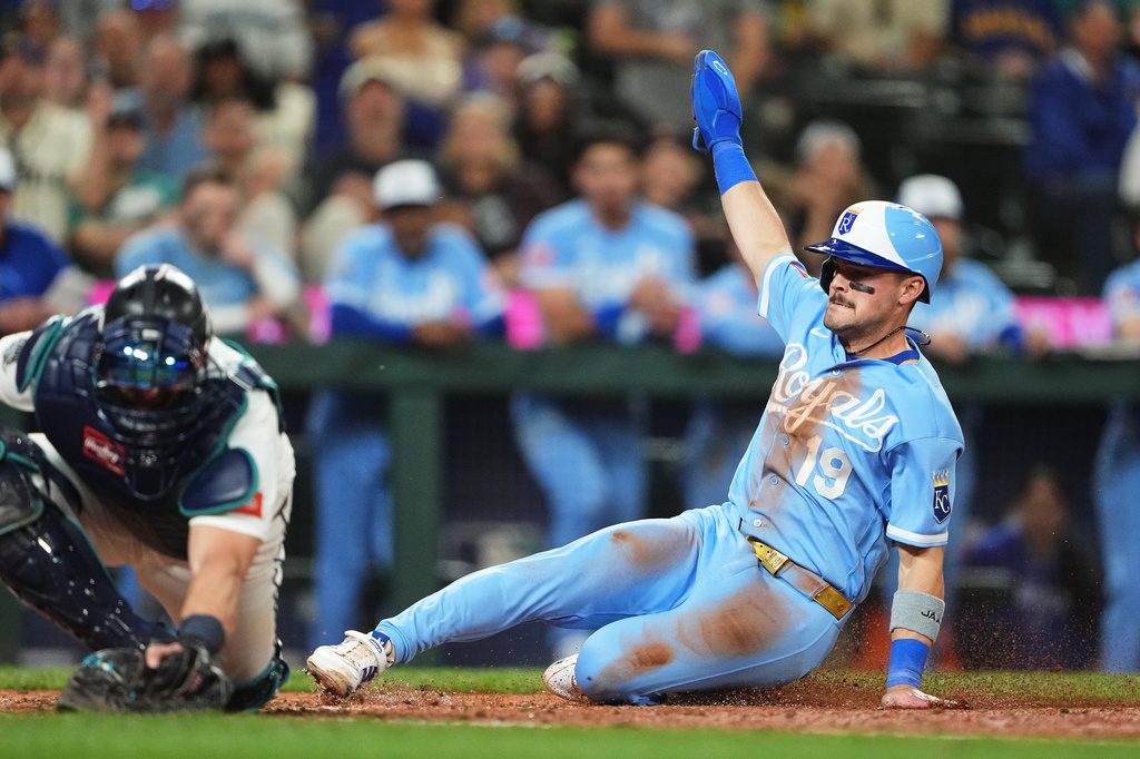 Kansas City Royals' Michael Massey scores on an RBI sacrifice fly from Isaac Collins ahead of the throw to Seattle Mariners catcher Mitch Garver during the 10th inning of a baseball game, Saturday, May 2, 2026, in Seattle. (AP Photo/Lindsey Wasson)