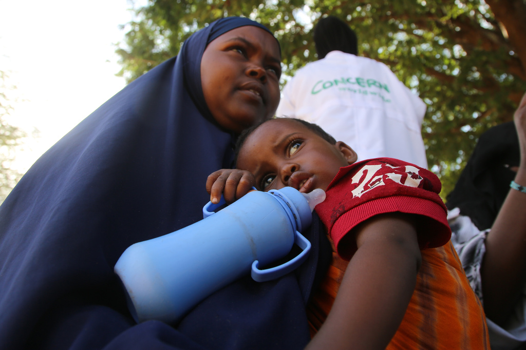A Somali woman displaced by drought sits holding her child at Feynuus Nutrition Centre on the outskirts of the capital, Mogadishu, Somalia, Wednesday, Aug. 19, 2026. (AP Photo/Farah Abdi Warsameh)