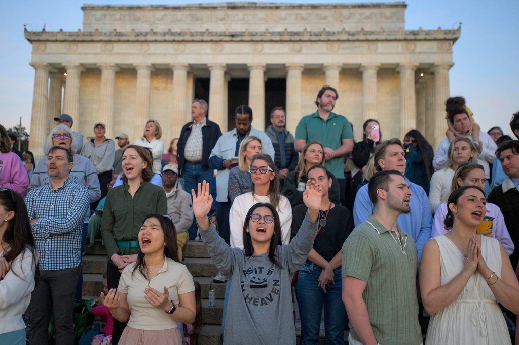 People raise their hands to the sky in song during an Easter Sunday sunrise prayer service at the Lincoln Memorial, Sunday, April 5, 2026, in Washington. (AP Photo/Rod Lamkey, Jr.)