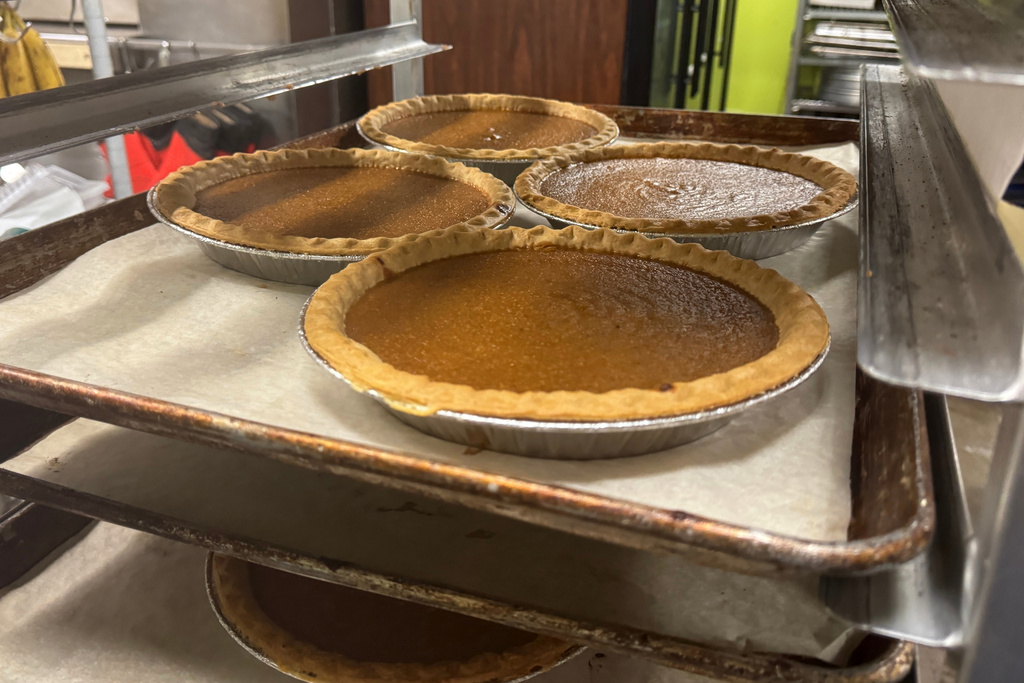 Pies, fresh out of the oven, cool on a baking rack on Friday, Nov. 21, 2025, in Flowood, Miss. (AP Photo/Sophie Bates)