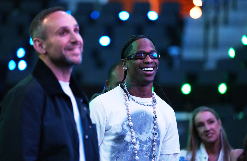 Rapper Travis Scott, center, stands alongside Fanatics founder and CEO Michael Rubin at the launch party for Fanatics Studio, a global studio for sports entertainment, on Tuesday, Jan. 13, 2026, at the Intuit Dome in Inglewood, Calif. (AP Photo/Chris Pizzello)