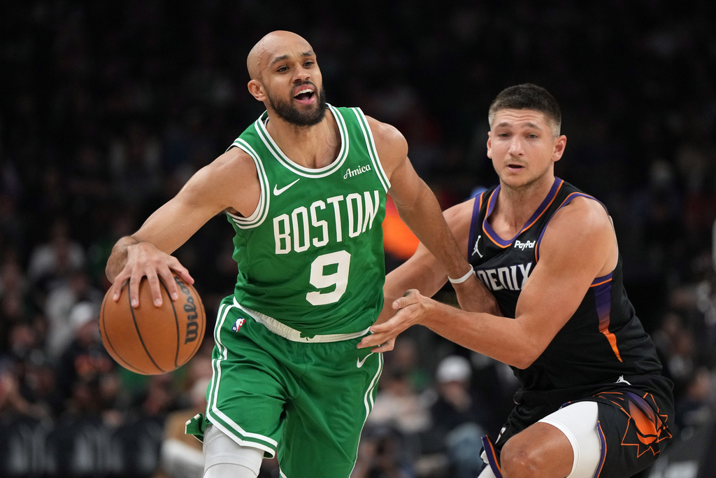 Boston Celtics guard Derrick White (9) drives past Phoenix Suns guard Grayson Allen during the first half of an NBA basketball game, Tuesday, Feb. 24, 2026, in Phoenix. (AP Photo/Rick Scuteri)